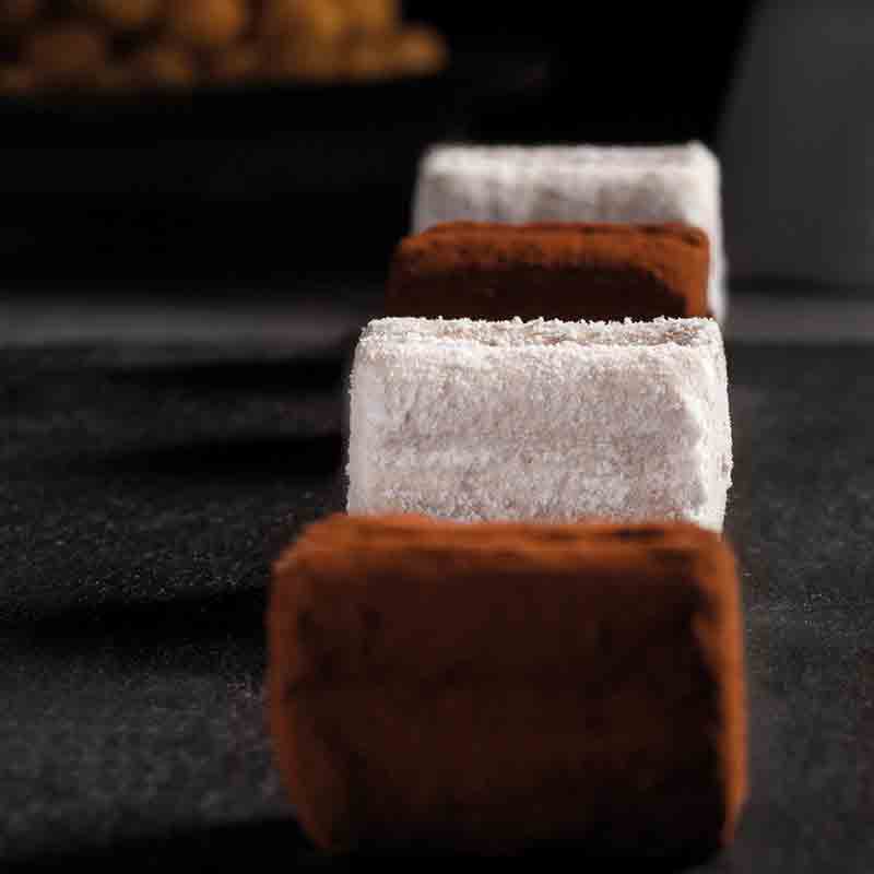 Feinkostpralinen auf schwarzem Hintergrund, Nahaufnahme, unscharfer Hintergrund.