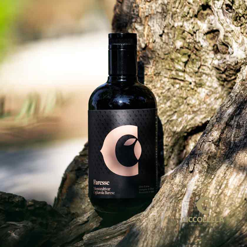 Flasche Paresse Olivenöl auf Baumstamm im Freien.