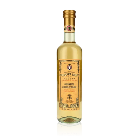 Giuseppe Giusti weißer Balsamico Essigflasche auf schwarzem Hintergrund.