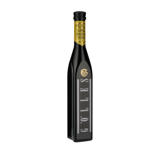 Gölles Apfel Balsamessig Flasche vor schwarzem Hintergrund.