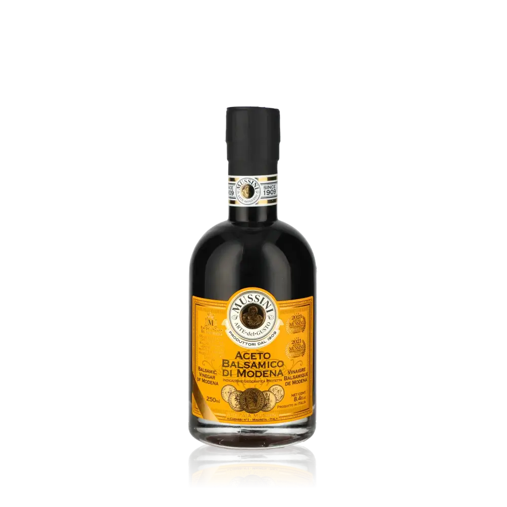 Mussini Aceto Balsamico di Modena Flasche vor schwarzem Hintergrund.