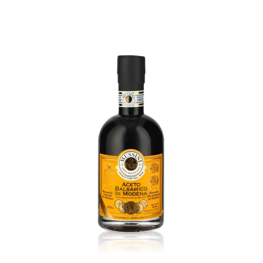 Mussini Aceto Balsamico di Modena Flasche vor schwarzem Hintergrund.