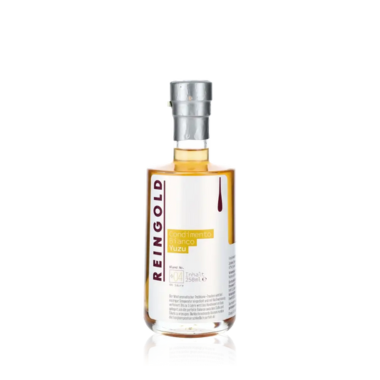 Reingold Condimento Bianco Yuzu Flasche vor schwarzem Hintergrund.