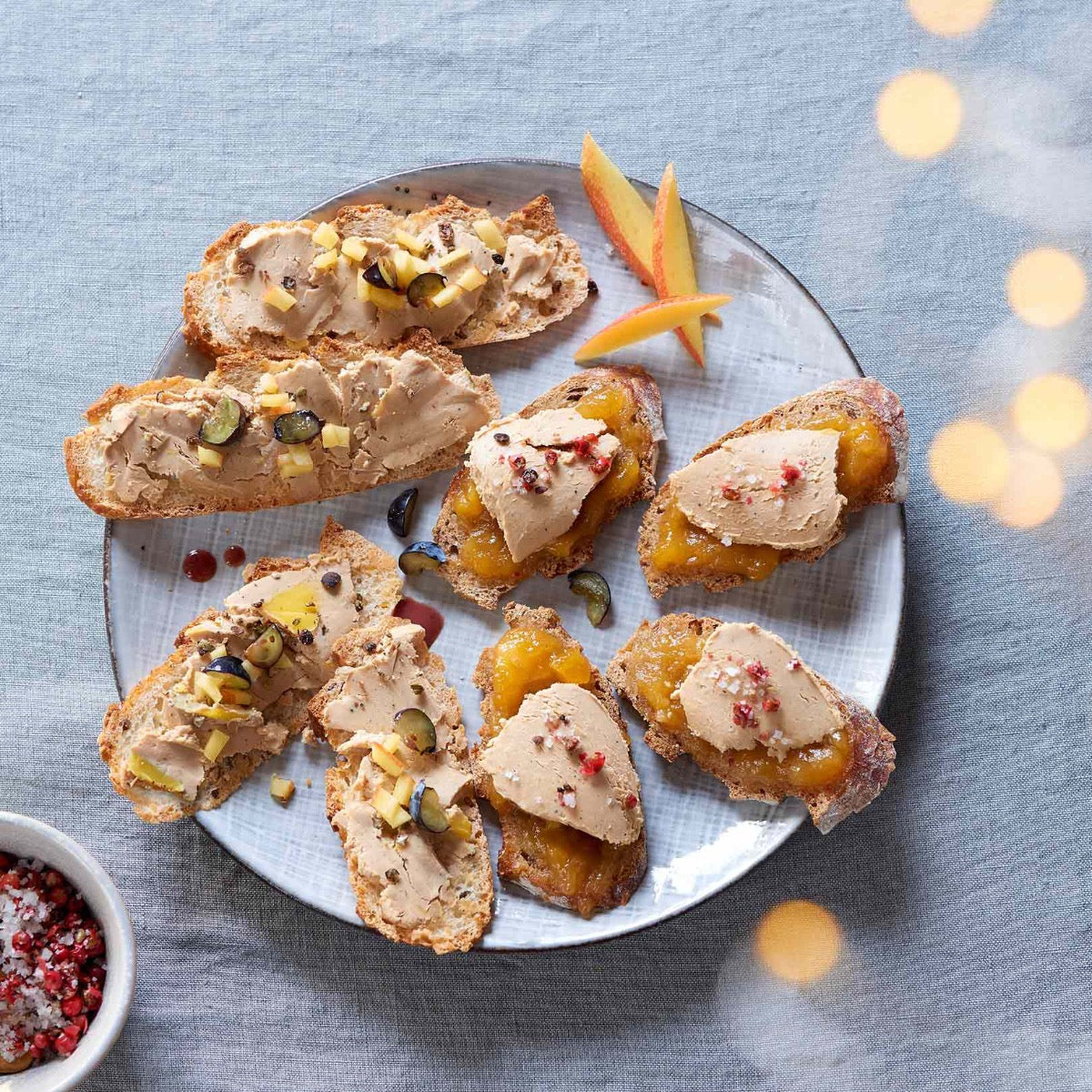 Brot mit Foie Gras und Früchten auf Teller angerichtet.