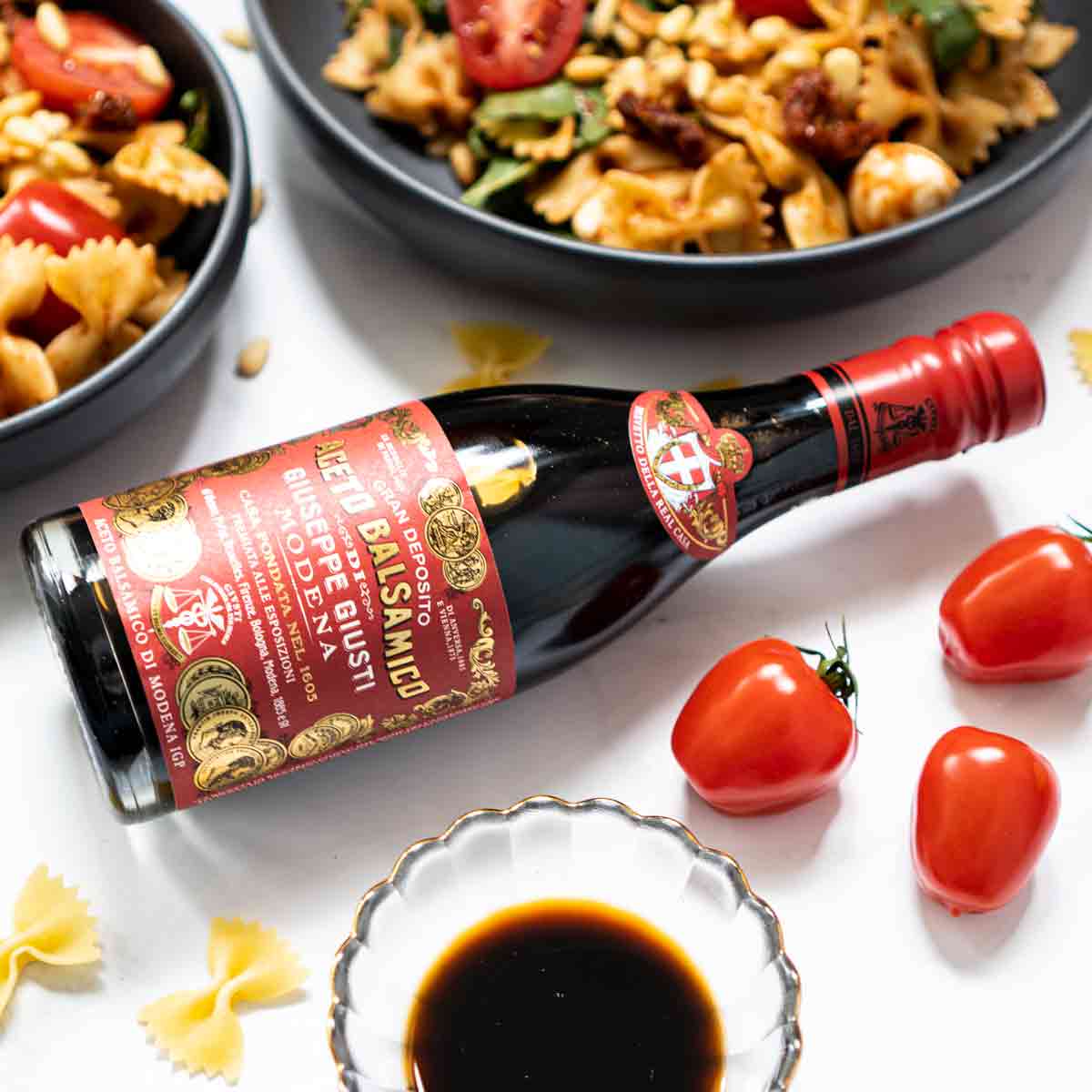 Balsamico-Essigflasche Giusti, Tomaten, Pasta, Schale mit Essig.