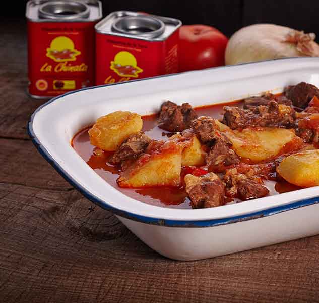 Eintopfgericht mit Fleisch und Kartoffeln in weißer Schale.
