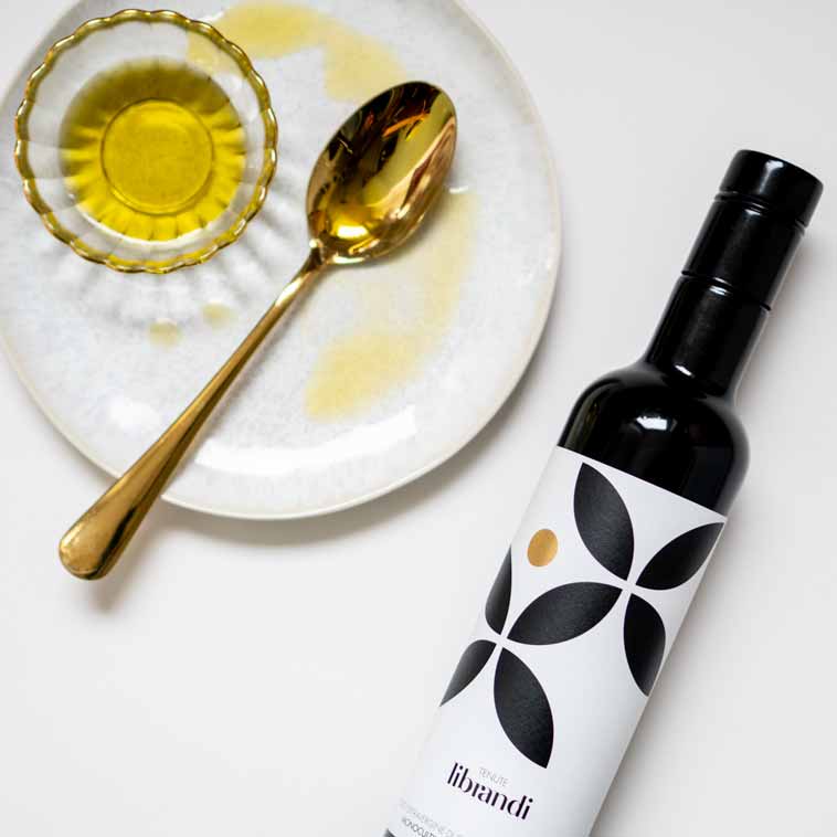 Librandi Olivenölflasche, goldener Löffel, Schale mit Olivenöl.