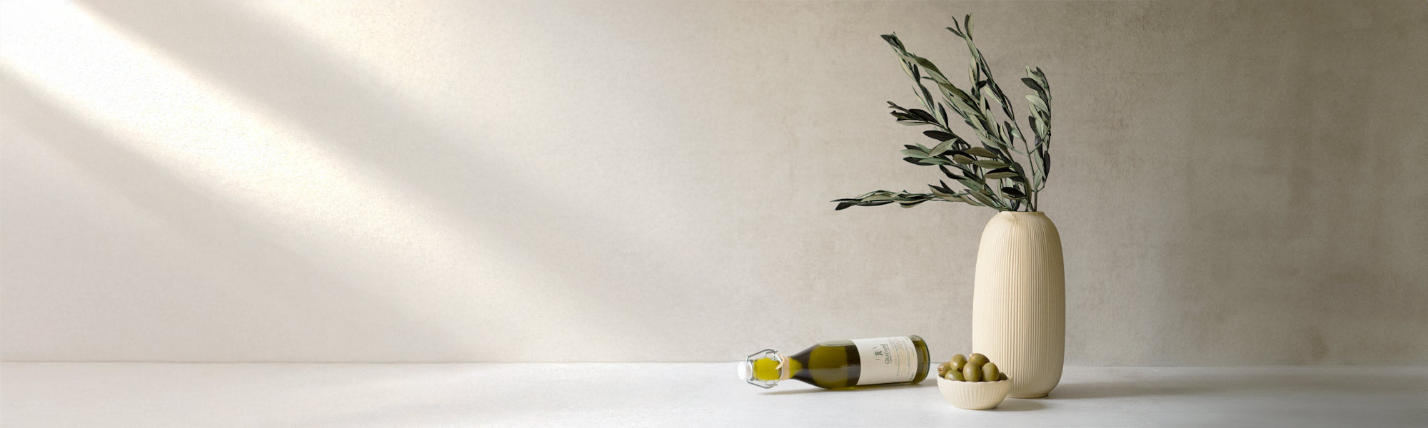 Olivenölflasche, Vase mit Olivenzweigen, Schale mit Oliven.