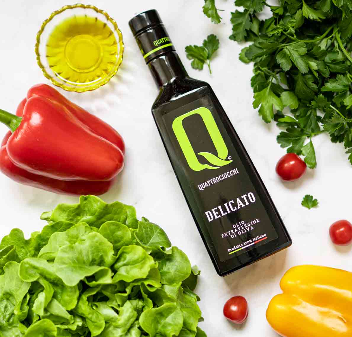 Quattrociocchi Olivenölflasche mit frischem Gemüse arrangiert.
