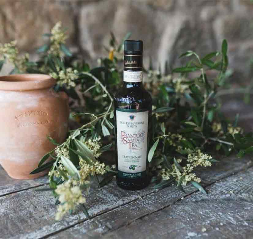 Flasche Frantoio Santa Tea Olivenöl auf Holztisch.