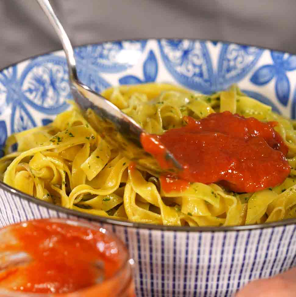 Pasta mit roter Sauce in einer blauen Schüssel.