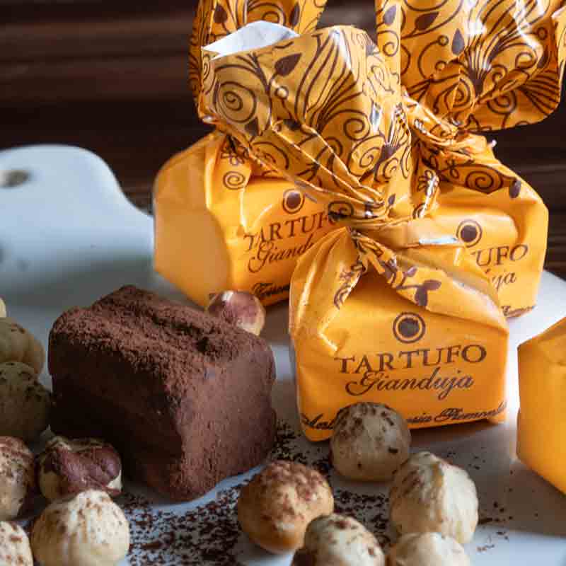 Tartufo Gianduja Pralinen mit Nüssen auf Teller arrangiert.