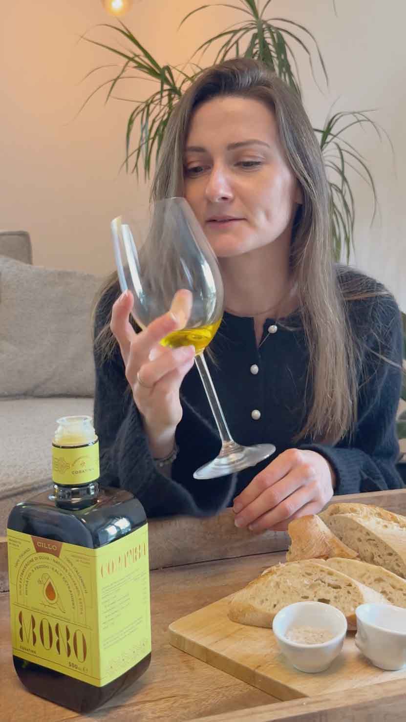 Eine Frau schaut auf ein Glas mit Olivenöl