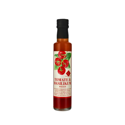 Murani Tomate Basilikum Balsamessig Flasche vor schwarzem Hintergrund.