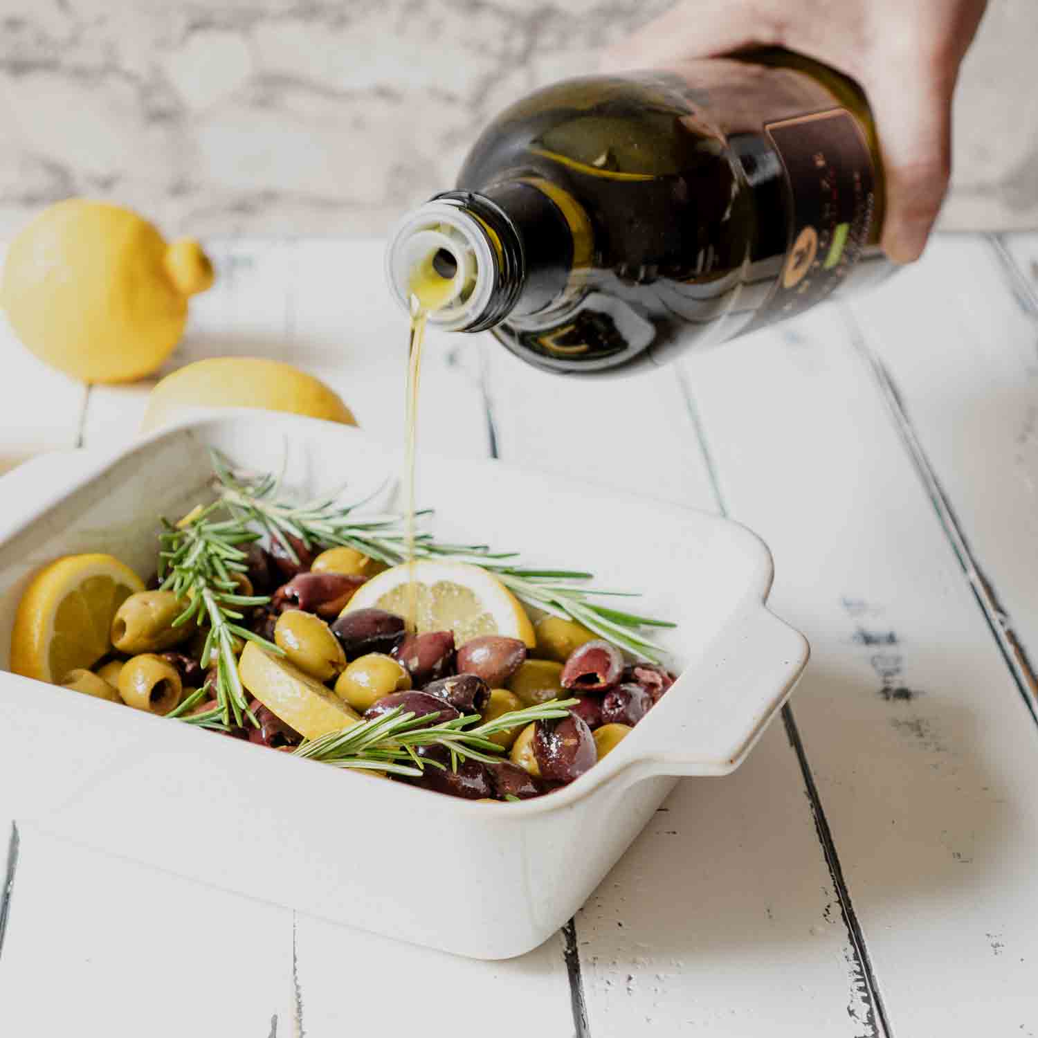 Olivenöl von Centonze über Oliven mit Rosmarin und Zitrone.