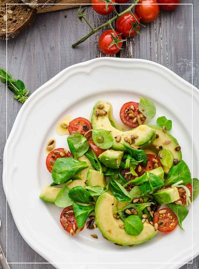 Avocado mit Tomate, Feldsalat und Pinienkernen